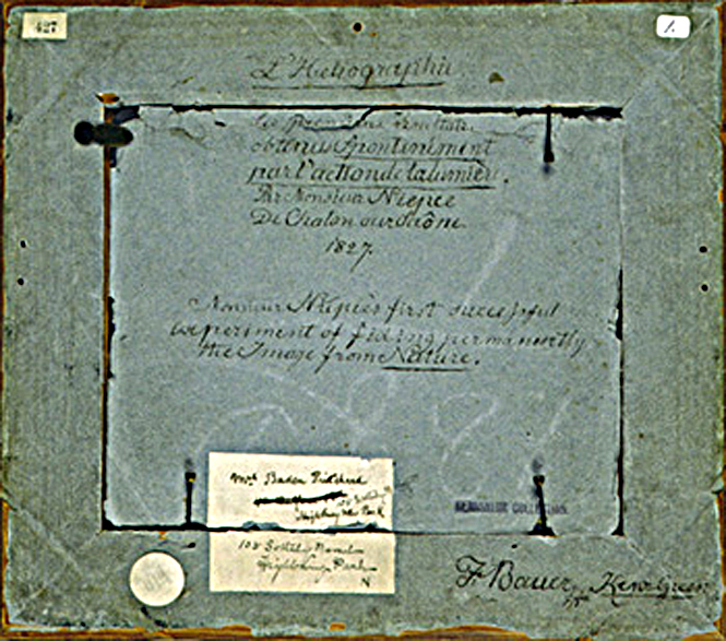 Manuscript notations and labels on the verso of Joseph Nicéphore Niépce's View from the Window at Le Gras. 1827-1963. Ink on paper backing of framed object. 25.8 x 29.0 cm.